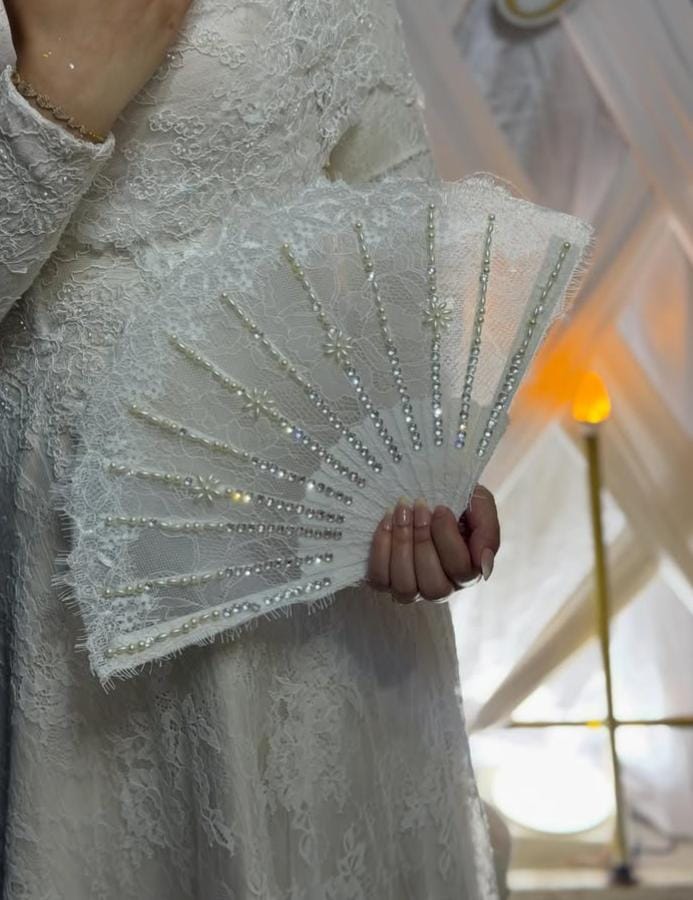 White beaded bridal fan in use